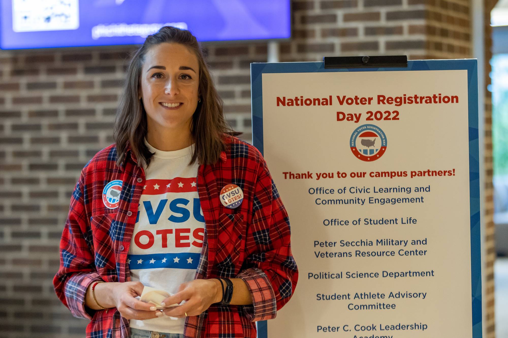 Person standing in front of the national voter registration day sign with a GVSU Vote t-shirt on